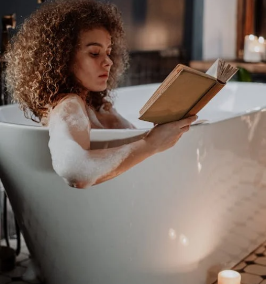 Woman reading a book in a tub.